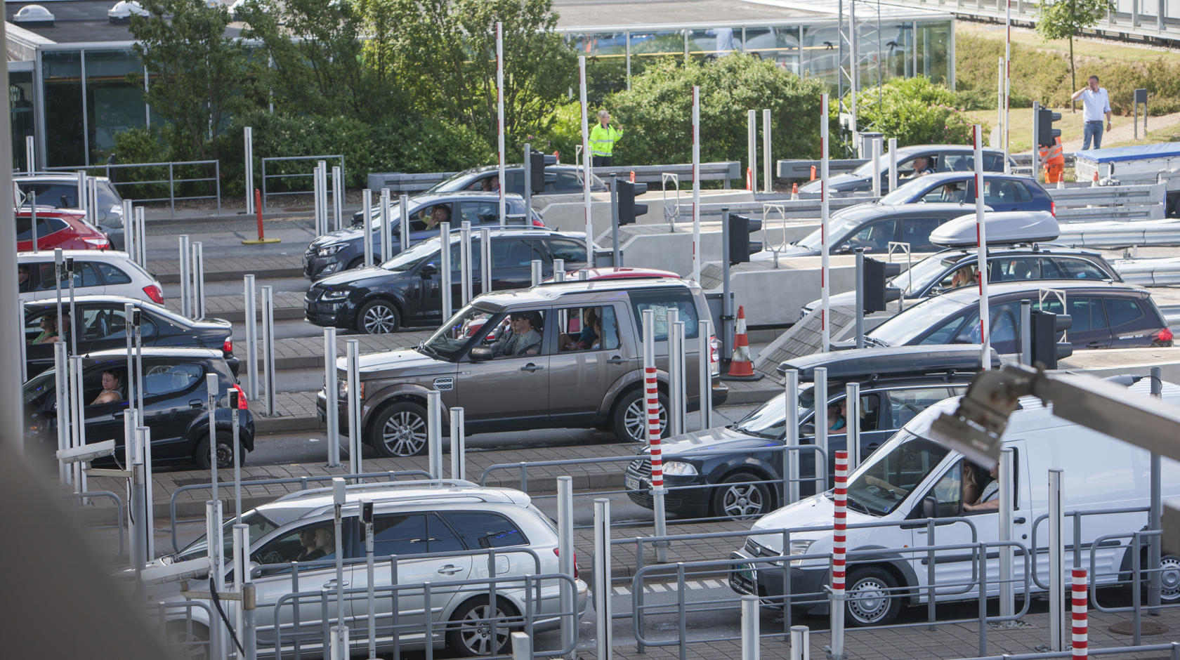 Etliche Autos stehen an einer Mautstation, um vor den rot-weißen Schranken die Straßenmaut zu bezahlen.
