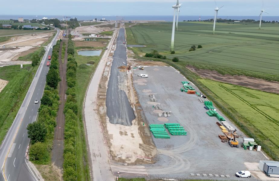 Das Luftbild zeigt in der Mitte die von Süden in Richtung Tunneleinfahrt verlaufende Bahntrasse. Deutlich zu erkennen, dass auf einem Großteil der Strecke bereits eine erste graue Schotterschicht aufgebracht worden ist.